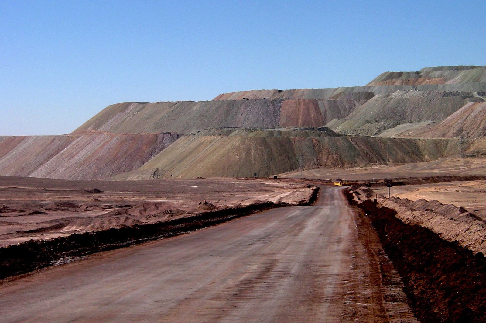 Une piste de roulage entre d’immenses verses à stériles dans le désert